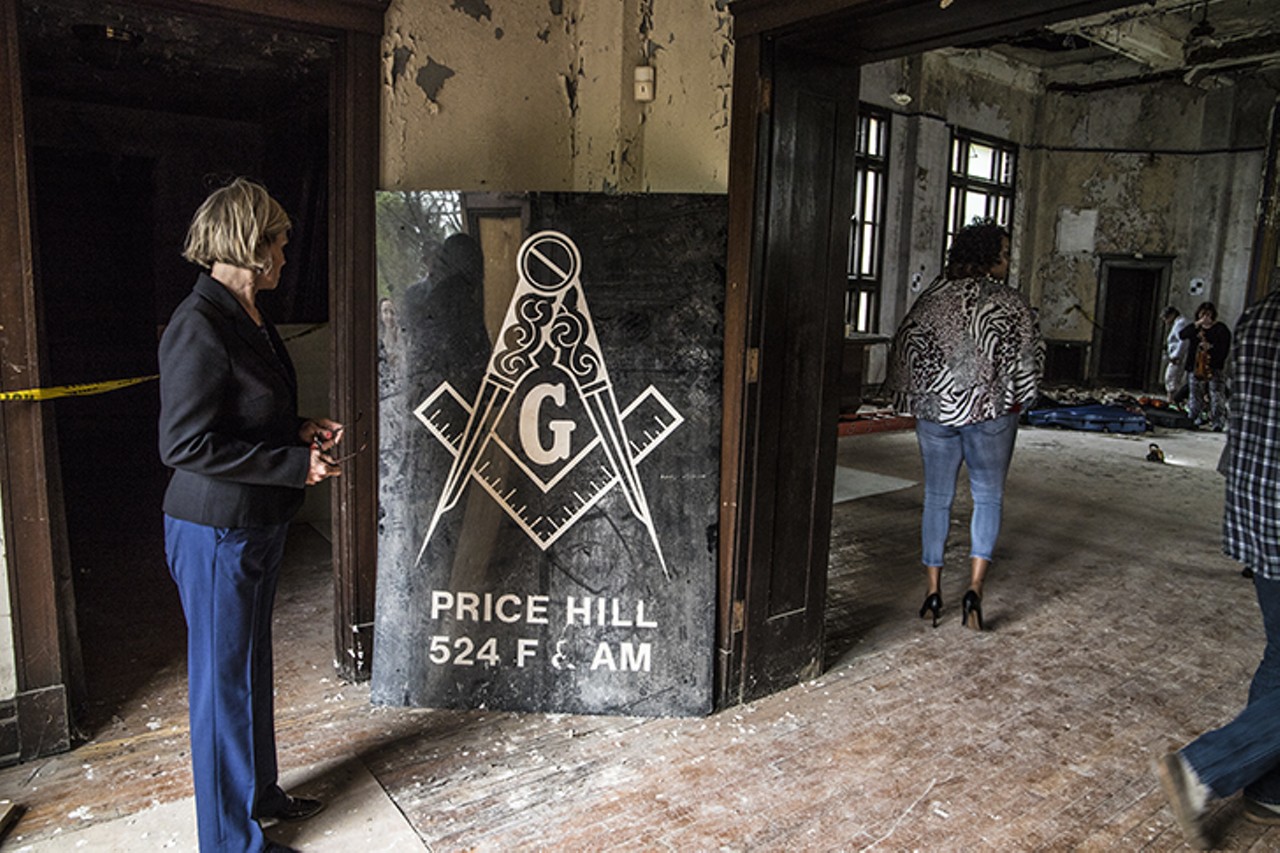 Port of Greater Cincinnati Redevelopment Authority President Laura Brunner examines a sign for the former Price Hill Masonic Lodge. The Port was a key player in securing financing for the lodge's $10 million renovation.