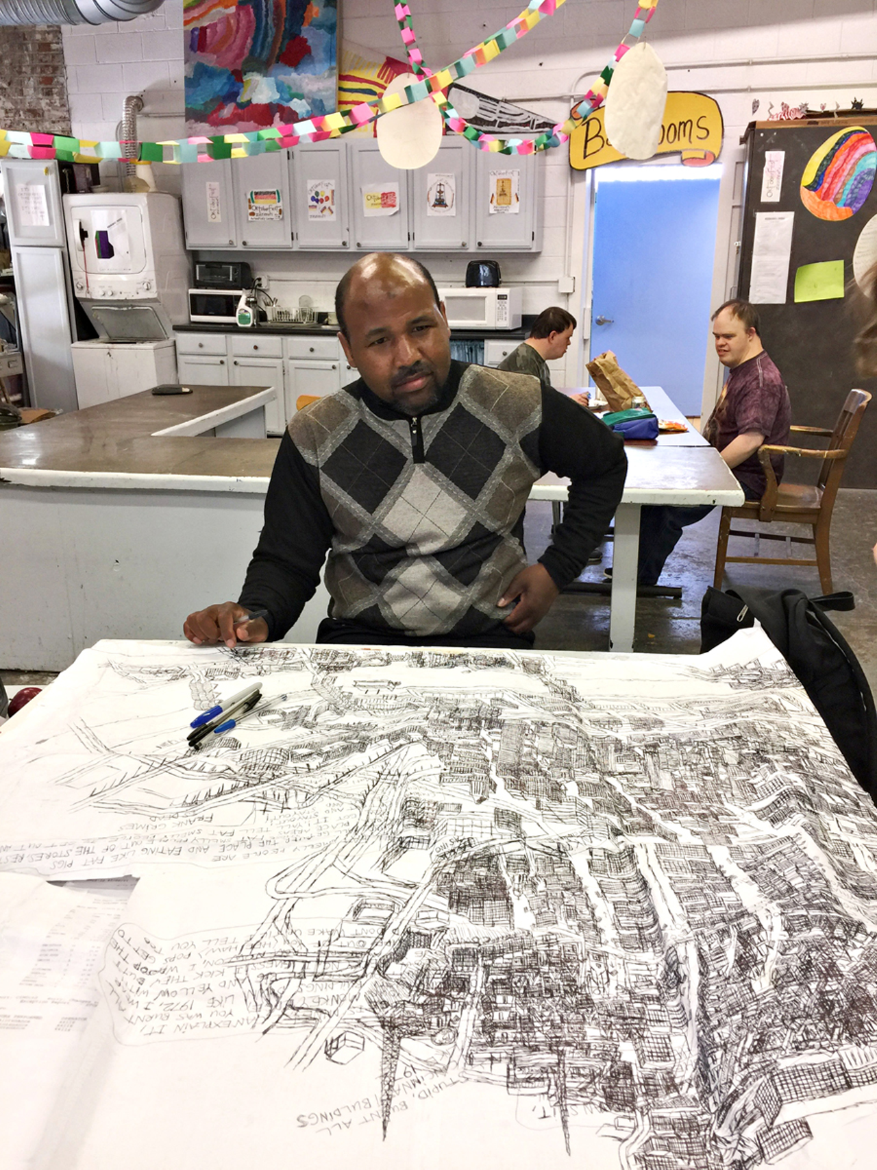 Courttney Cooper at work on one of his signature Cincinnati map drawings