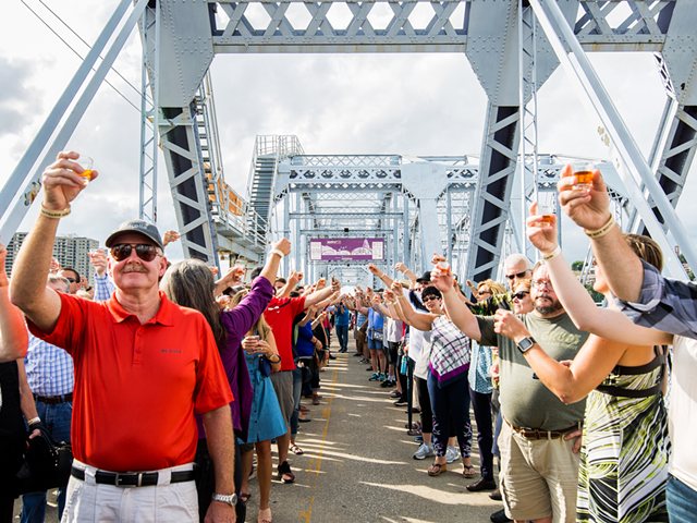 An image of the 2018 "World's Biggest Bourbon Toast" on the Purple People Bridge to celebrate the release of New Riff Distilling's first batch of bourbon.