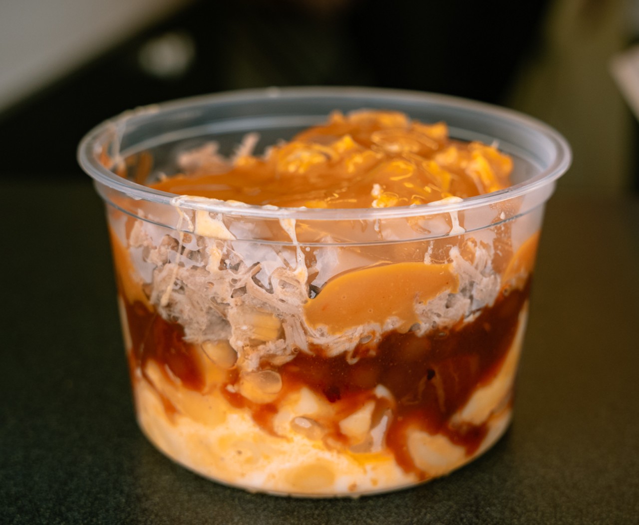 Smokin' Dews' The Piggy Pileup features four ounces of their homemade macaroni and cheese, baked beans and two ounces of pulled pork or chicken smothered in your choice of sauce, all piled on top of one another.