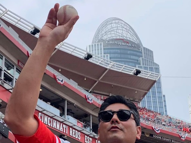 Cincinnati Mayor Aftab Pureval celebrates catching a foul ball during the Cincinnati Reds' home opener at Great American Ball Park on April 12, 2022.