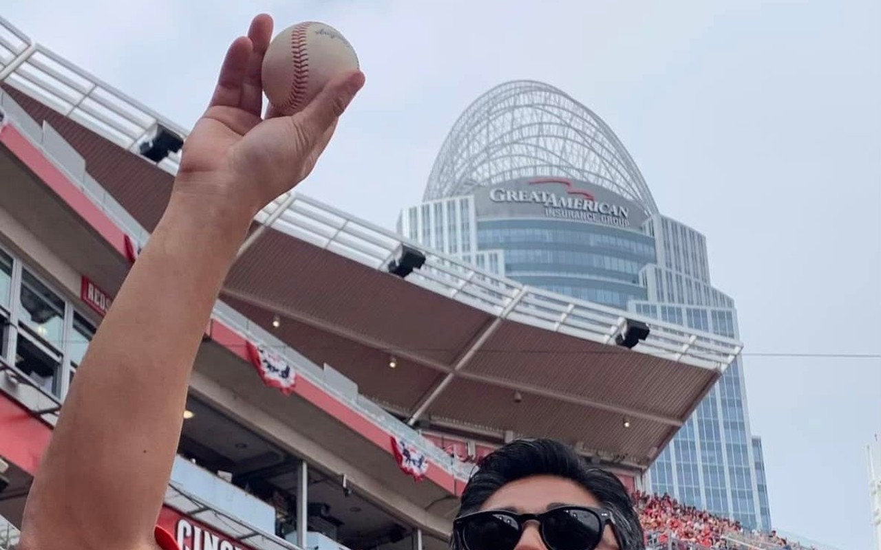 Cincinnati Mayor Aftab Pureval celebrates catching a foul ball during the Cincinnati Reds' home opener at Great American Ball Park on April 12, 2022.