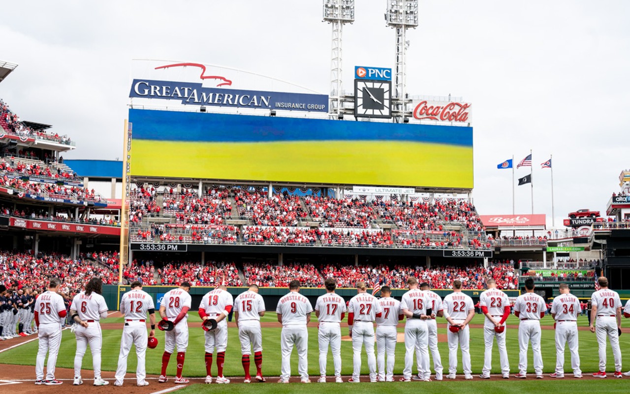 The Cincinnati Reds stand for the National Anthem before the home opener at Great American Ball Park on April 12, 2022.