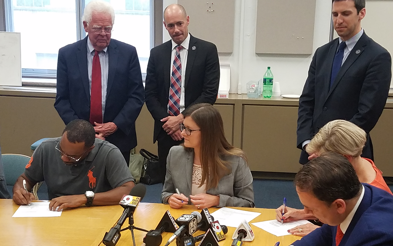 Council members P.G. Sittenfeld, Greg Landsman and David Mann look on as FCC GM Jeff Berding, Greater Cincinnati Redevelopment Authority CEO Laura Brunner and West End representatives sign a revised CBA.