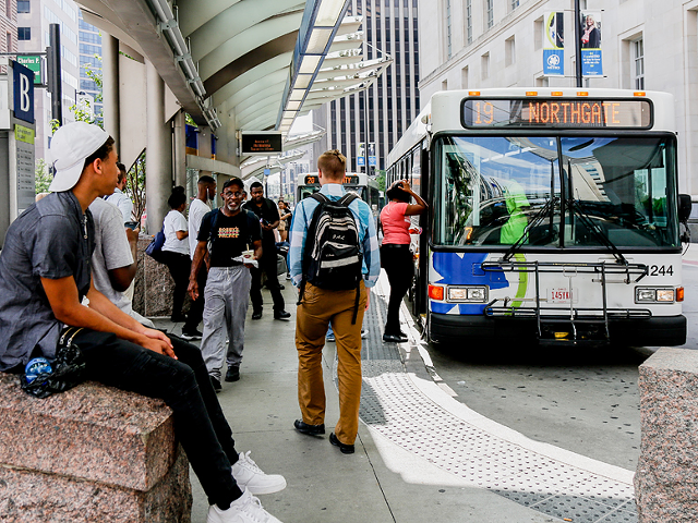 Riders wait for a Route 19 bus at Government Square downtown.