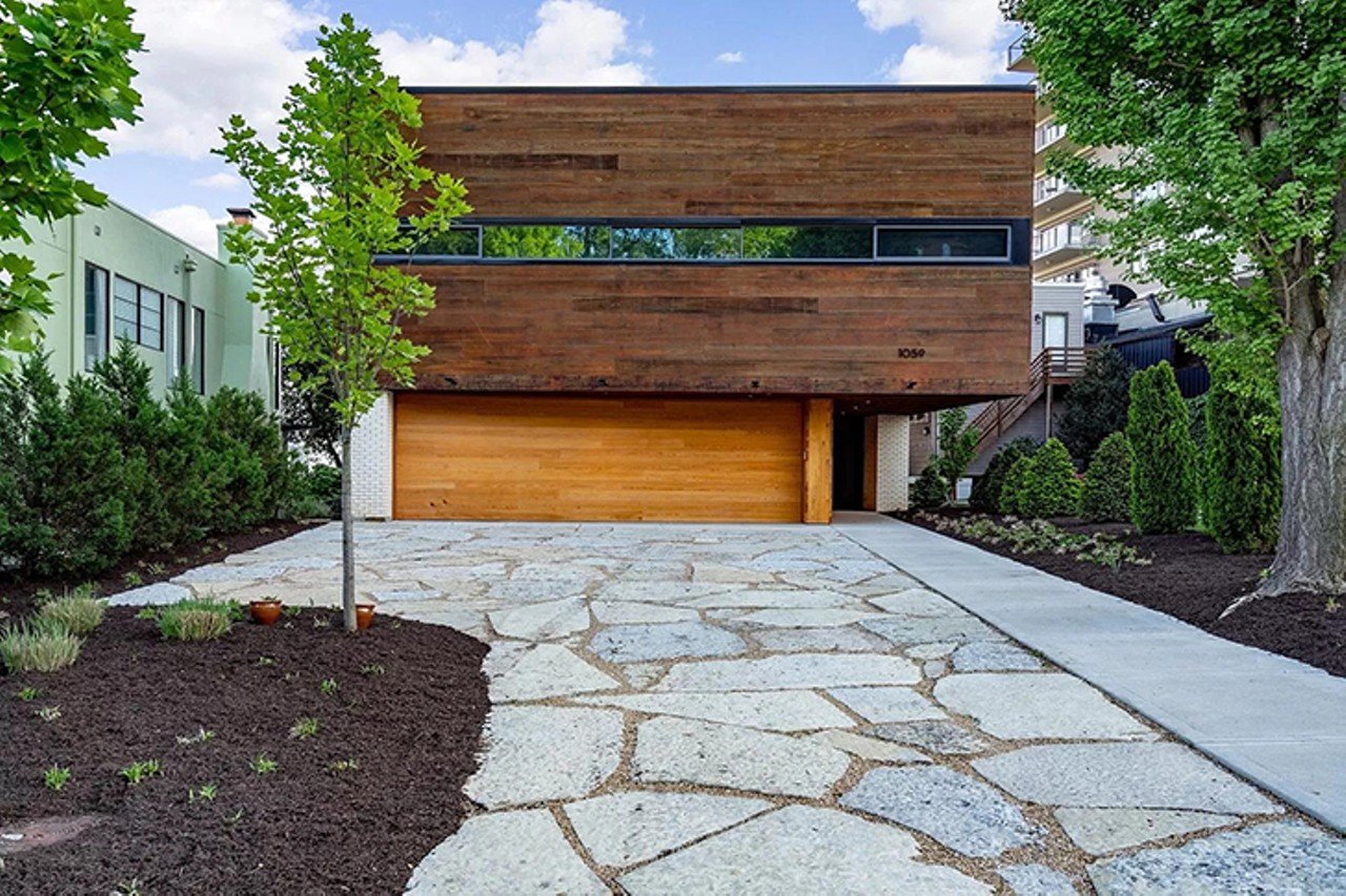 1059 Celestial Street, Mount Adams
$3,249,000 | 4 bd/4 ba | 6,778 sq. ft. | Year Built: 2017
Situated along the hillside of Cincinnati's Mt. Adams neighborhood, this incredible contemporary home was built by renowned Cincinnati-based architect Jose Garcia.
The abode is priced at $3.25 million &#151; a rather steep price. But while it may not fall into most of our budgets, we can certainly admire its striking architecture and design through photographs.
Located at 1059 Celestial St., the home was built in 2017 and features a massive rooftop patio boasting panoramic views of the city and river, and a firepit. The space spans a whopping 6,778 square feet with 4 bedrooms and 3.5 baths. Inside, the home features walls of windows, and an open floor plan with the kitchen and living room opening out to a large patio with spectacular views. But a real stunner is the cute little interior arboretum with a tree in the middle.