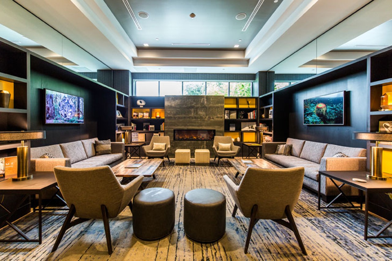 The library and entertainment space features cozy seating, multiple TVs and a pool table