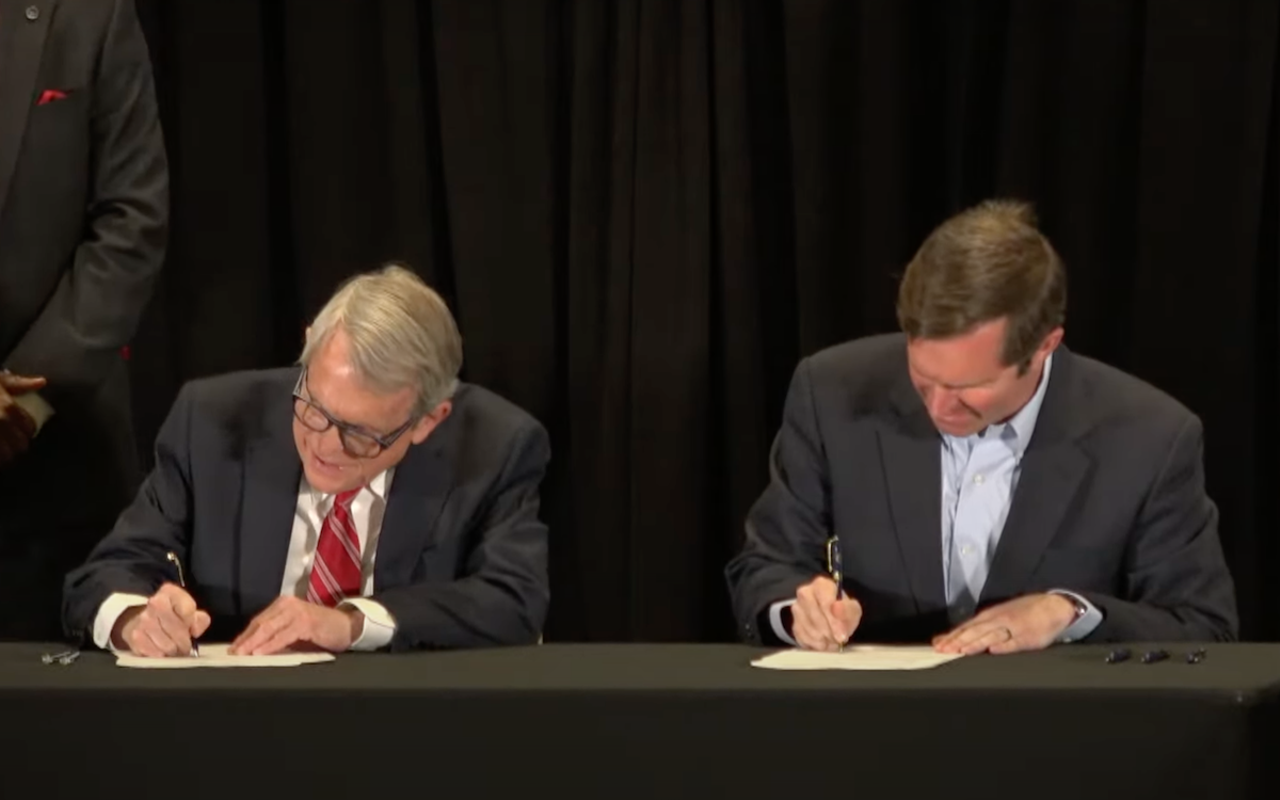 Ohio Gov. Mike DeWine (left) and Kentucky Gov. Andy Beshear sign a memorandum of understanding regarding the Brent Spence Bridge connecting the states on Feb. 28, 2022.