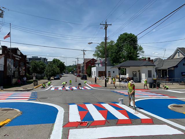 Volunteers paint a Dayton intersection before Memorial Day Weekend.