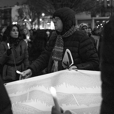 Attendees of the Peace Vigil for Gaza event at Washington Park on Dec. 17 hold a large scroll with the names of the Palestinians killed in Gaza since Oct. 7.