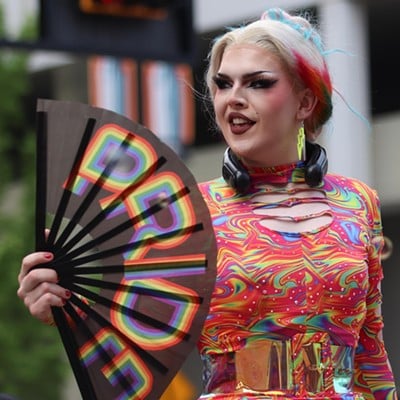 A participant fans herself at the Cincinnati Pride Parade on Saturday, June 22, 2024.