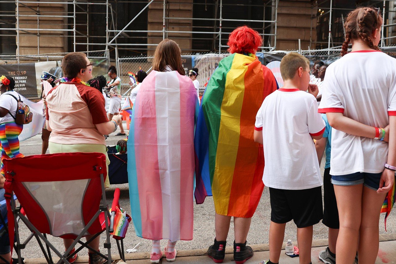 Spectators wrap themselves in Pride flags at the Cincinnati Pride Parade on Saturday, June 22, 2024.