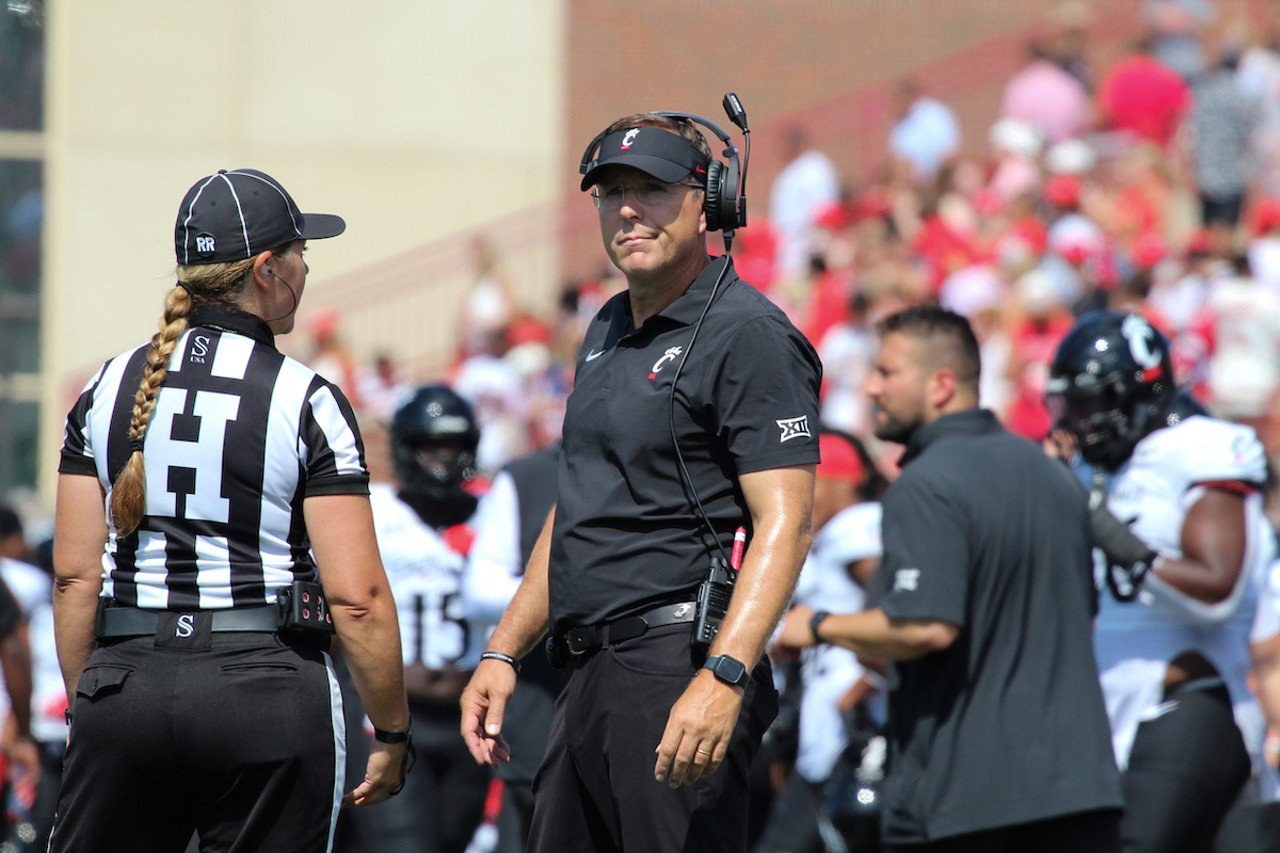 UC head football coach Scott Satterfield talks with referees while a play is reviewed.