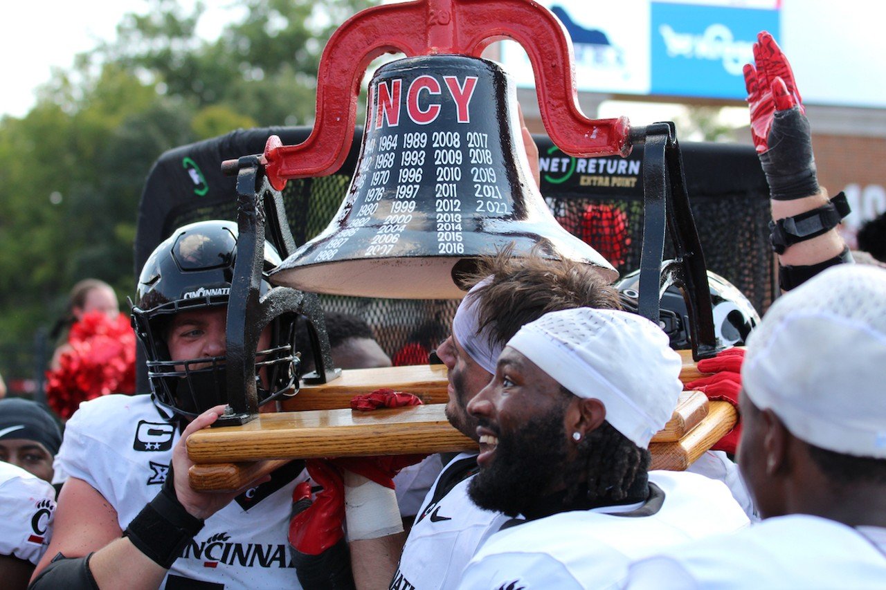 University of Cincinnati players carry the Victory Bell toward UC fans.