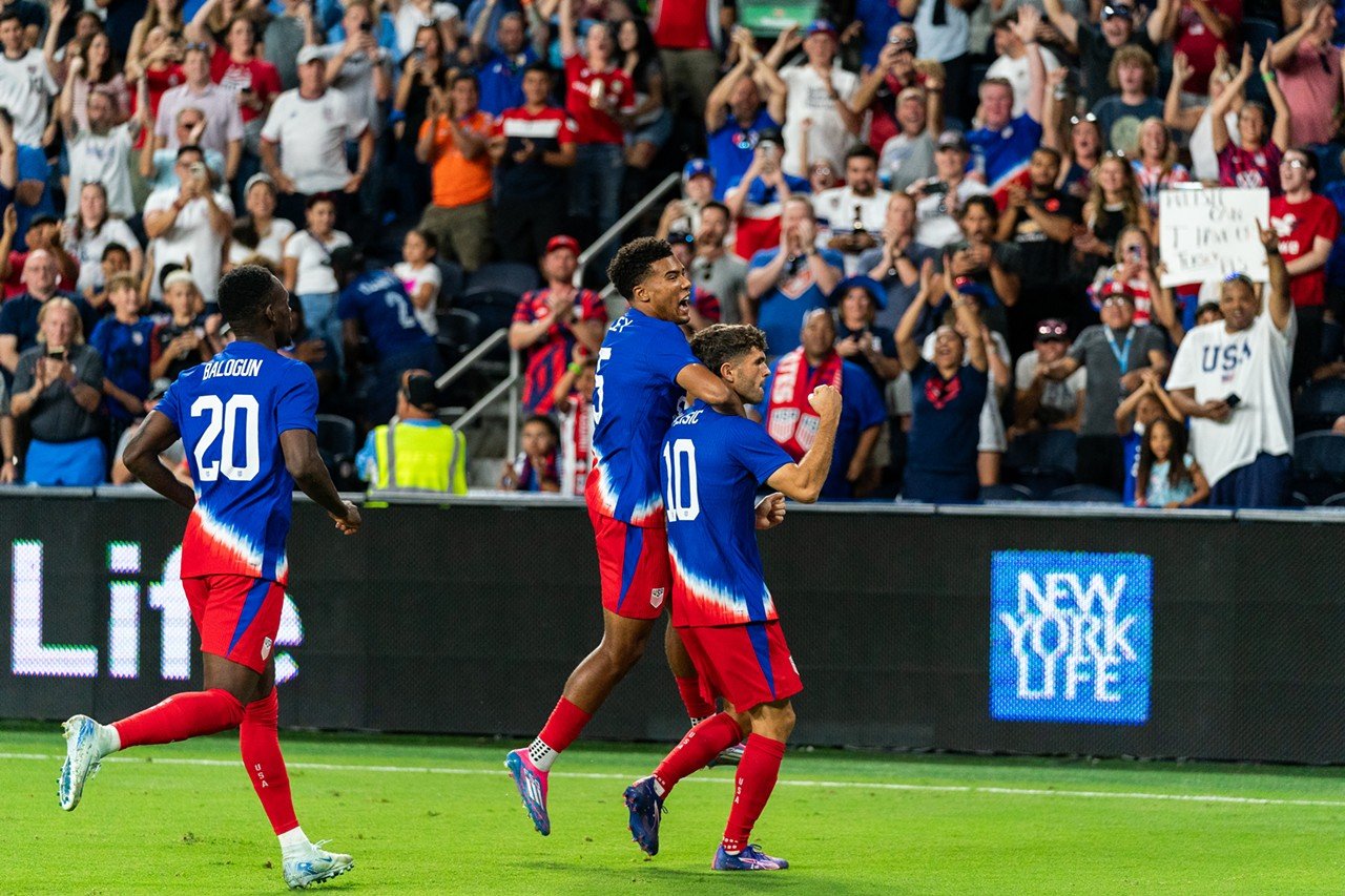 Christian Pulisic celebrates with teammates following his goal.