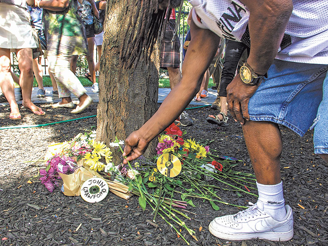 Attendees at a march for racial justice last year place flowers near where Timothy Thomas was shot in 2001. Thomas’ death sparked unrest and ongoing reform efforts in Cincinnati.