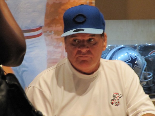 Former Cincinnati Reds player and manager Pete Rose signs baseballs in 2010.