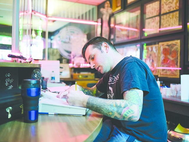 Carter Gilliss works on a tattoo design at Designs by Dana in Northside.