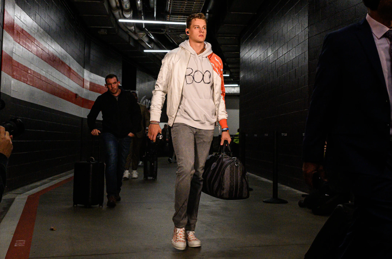 Cincinnati Bengals quarterback Joe Burrow wears a white satin jacket, "boo" hoodie and denim before the game against the Cleveland Browns on Oct. 31, 2022.