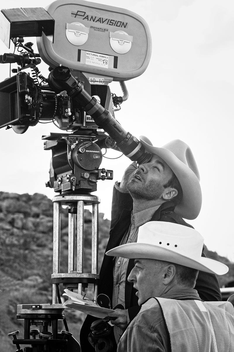 Director Tom Ford looking through a camera on the set of Nocturnal Animals. - Photo: Merrick Morton/Focus Features
