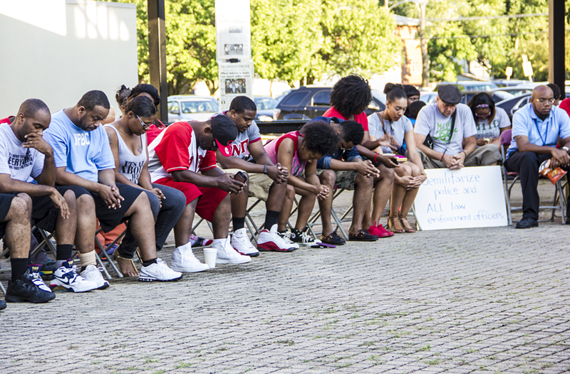 Attendees at an Aug. 14 vigil in Roselawn observe a moment of silence for Michael Brown, John Crawford and others who have been killed by law enforcement officers across the country.