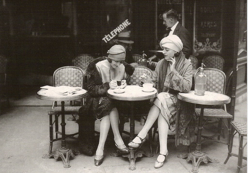 A picture of a postcard of two French flappers, circa 1920s. - "French Flappers, Parisian Cafe 1920's" by Vintage Lulu/Creative Commons