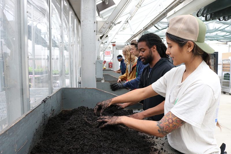 Green Corps members prepare soil for seeding at a community greenhouse. The oak trees and milkweed grown with this soil will either be used to provide sites like Little Duck Creek with native plants or sold to interested buyers. - SETH WEBER