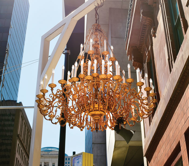Werner Reiterer's large brass chandelier hangs from a white scaffold in front of 21 Museum Hotel. - Photo: Jesse Fox