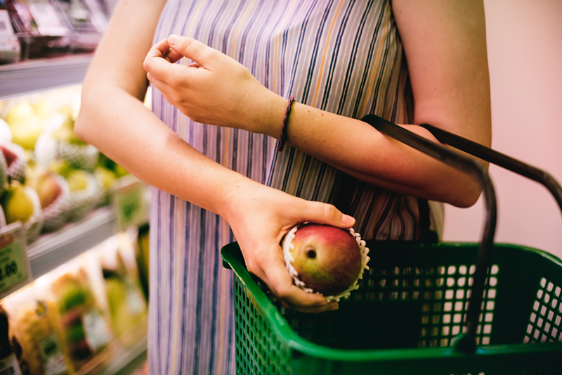 After picking out the perfect fruit, shopper pauses when she realizes she left her required photo ID in her other purse. - Photo: Rawpixel