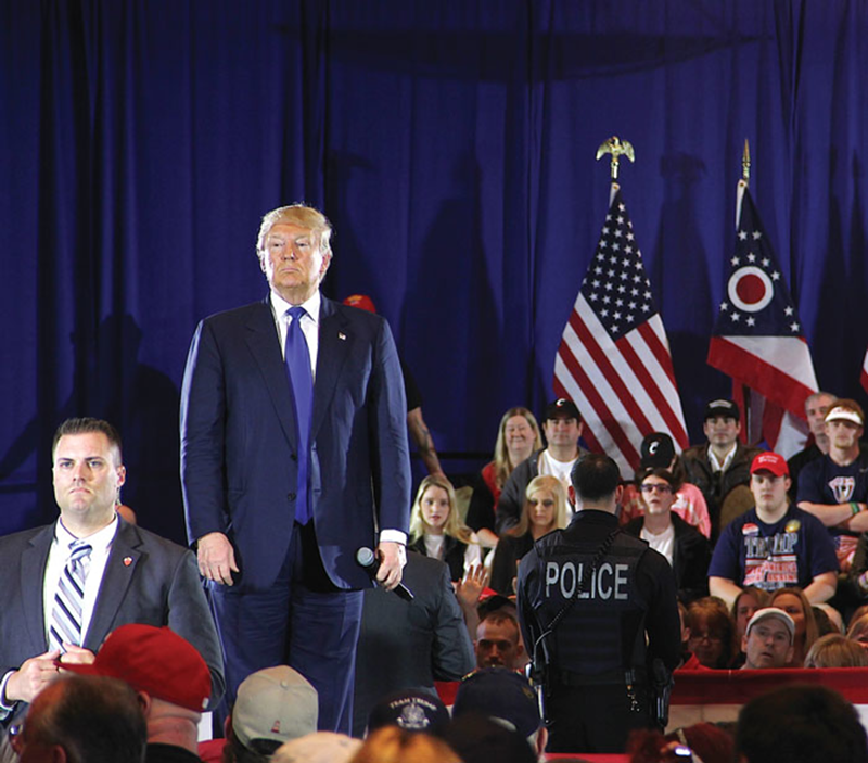 GOP presidential primary frontrunner Donald Trump stands with security personnel at a March 13 campaign rally in West Chester.