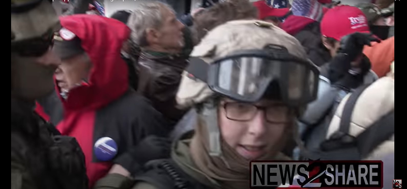 A still from footage of the riots in Washington, D.C. captures a woman, seen with several people in Oathkeepers regalia, matching the likeness of a woman seen at the Ohio Capitol in November.