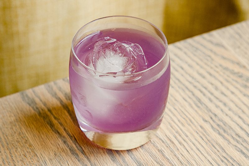 The She-Wolf, with Old Tom Gin and pear, ginger and elderflower liqueurs. It is a vivid purple color and comes served in a tumbler with a rose-shaped ice cube. - Photo: Hailey Bollinger