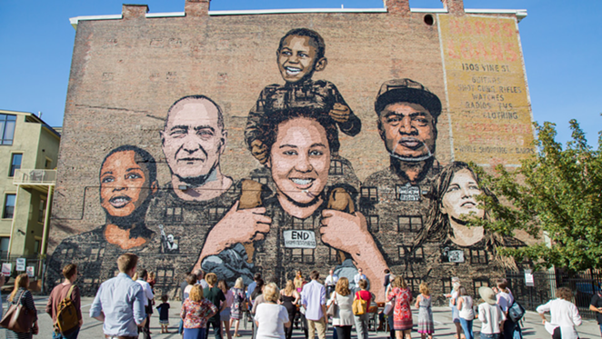 The "Faces of Homelessness" mural on the side of the Recovery Hotel. - Photo: Hailey Bollinger