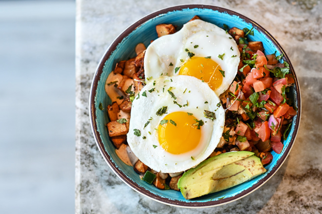 Yuca's The Hangover: Two sunny side-up eggs laying on a bed of spicy chorizo and homemade potatoes with pico de gallo and avocado on top - PHOTO: FRANCISCO HUERTA