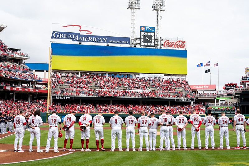 The Cincinnati Reds stand for the National Anthem before the home opener at Great American Ball Park on April 12, 2022. - PHOTO: RON VALLE