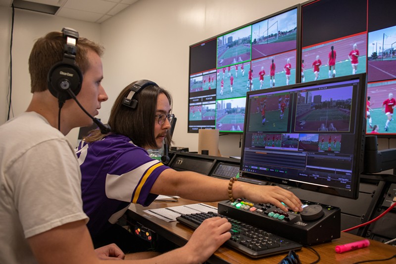 Jeremy Youngquist (in purple) assists Alex Jacob in banking clips for player packages in the broadcast control center at the University of Cincinnati. - Photo: Michael Asher