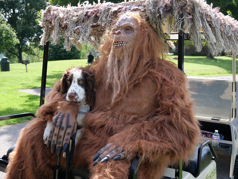 A person in a Bigfoot costume and their dog Trevor hitch a ride on a golf cart during Bigfoot Basecamp in September 2022. - Photo: Allison Babka