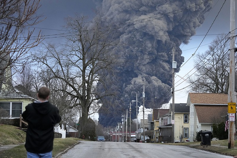 A man takes photos as a black plume rises over East Palestine, Ohio, as a result of a controlled detonation of a portion of the derailed Norfolk Southern train, Feb. 6, 2023. After toxic chemicals were released into the air from a wrecked train in Ohio, evacuated residents remain in the dark about what toxic substances are lingering in their vacated neighborhoods while they await approval to return home. (AP Photo/Gene J. Puskar, File) - Photo: AP Photo/Gene J. Puskar, File