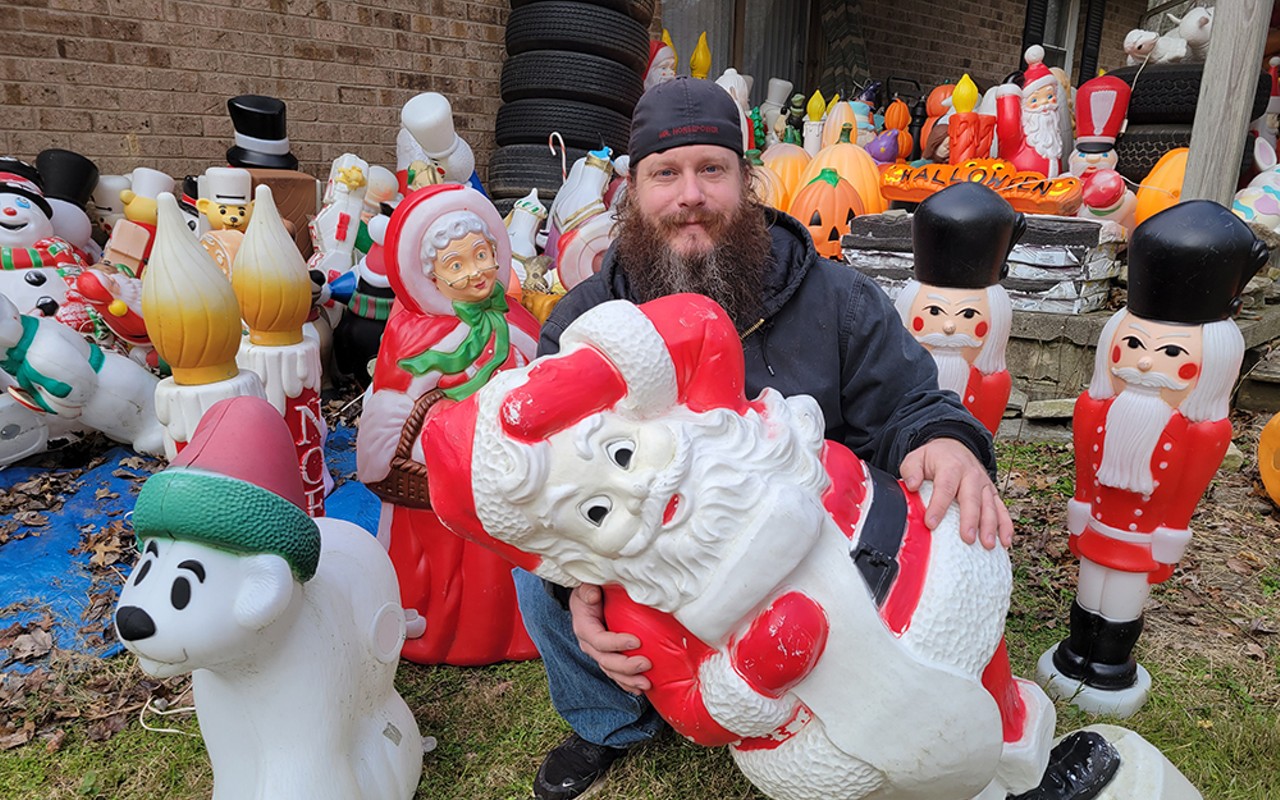 Jason Dunham holds one of his 150 Christmas blow molds behind his house.