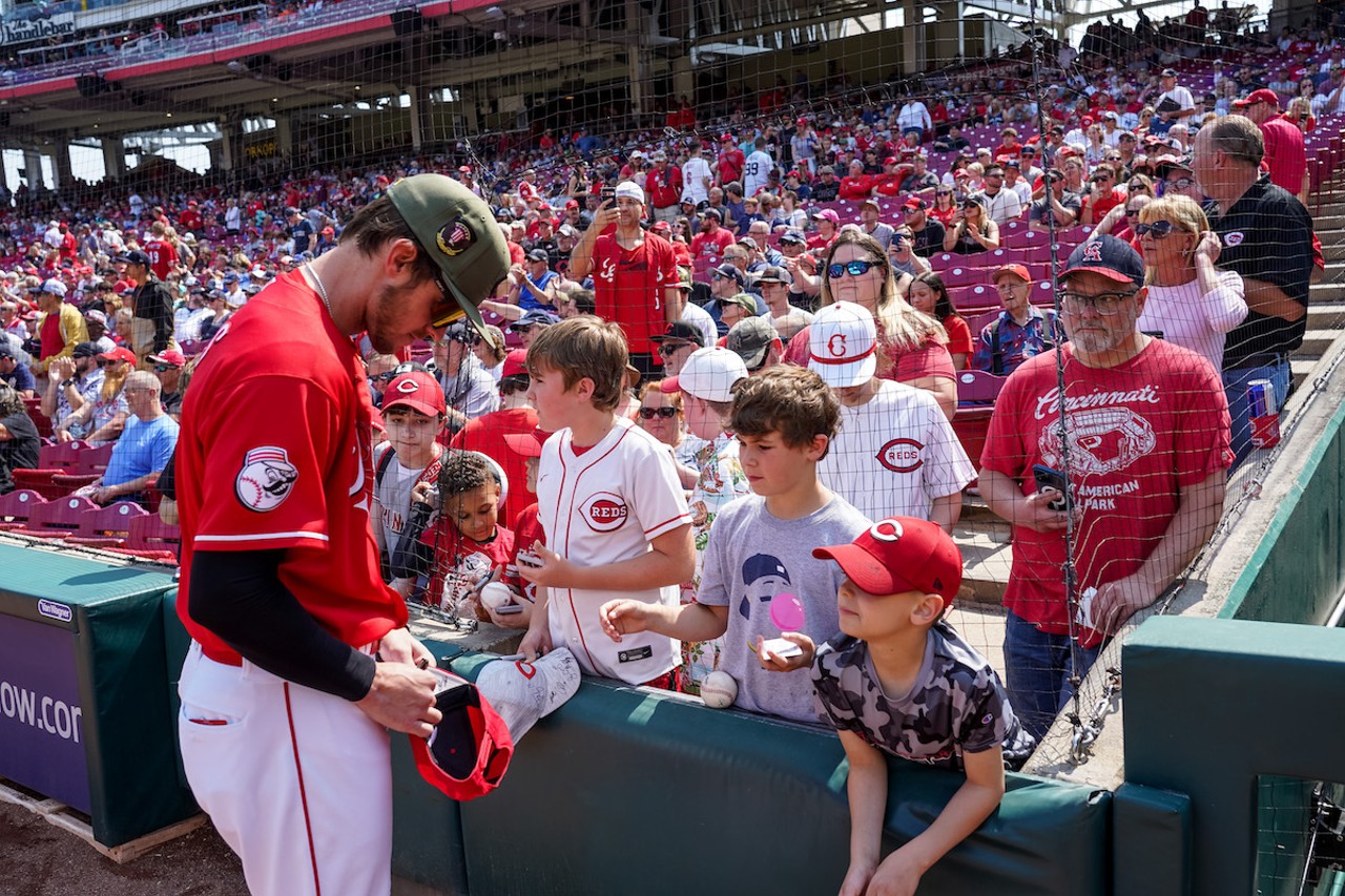 Cincinnati Reds outfielder Wil Myers signs a hat.